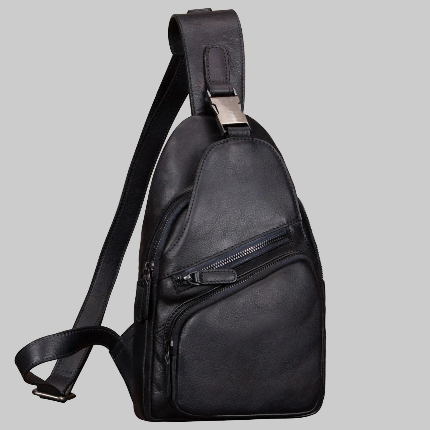 Black leather sling bag on a light gray background