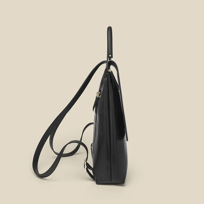 Black backpack with a shoulder strap on a beige background