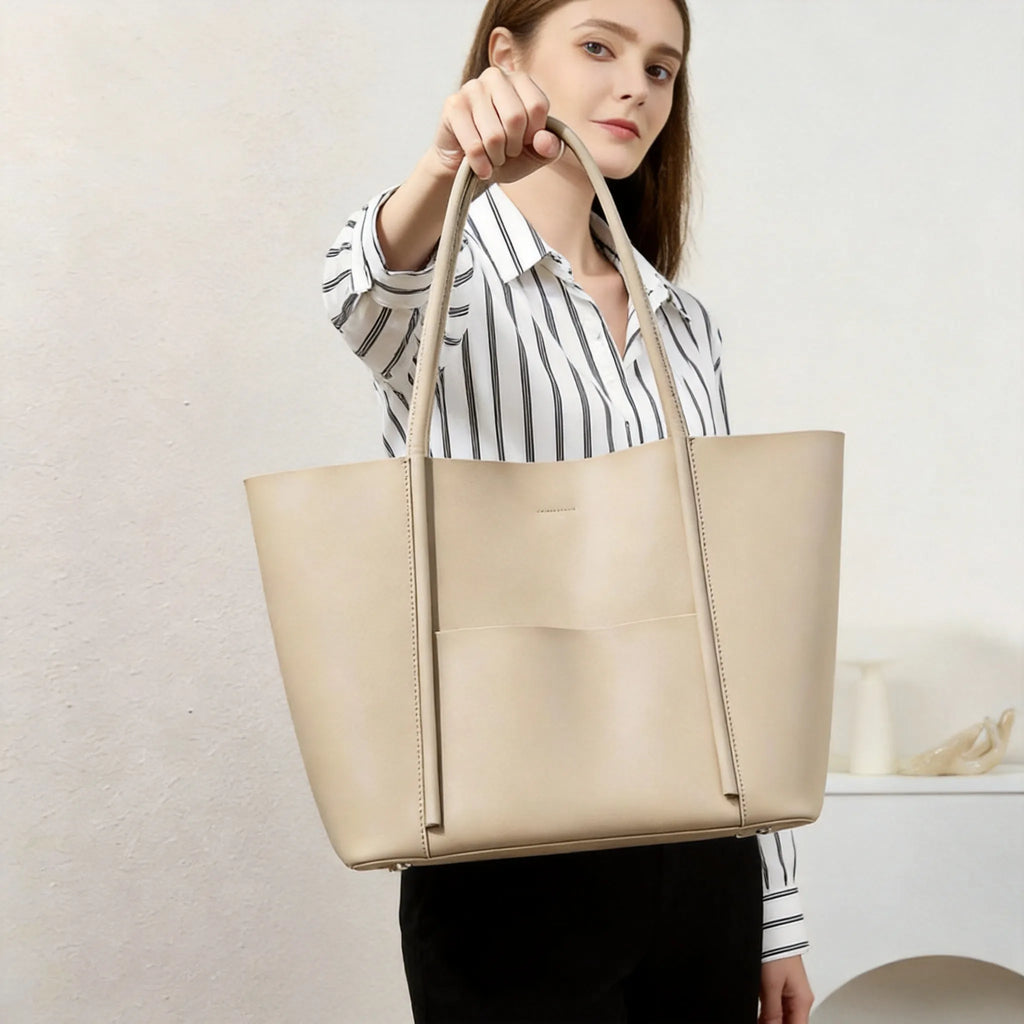 Woman holding a beige tote bag against a neutral background