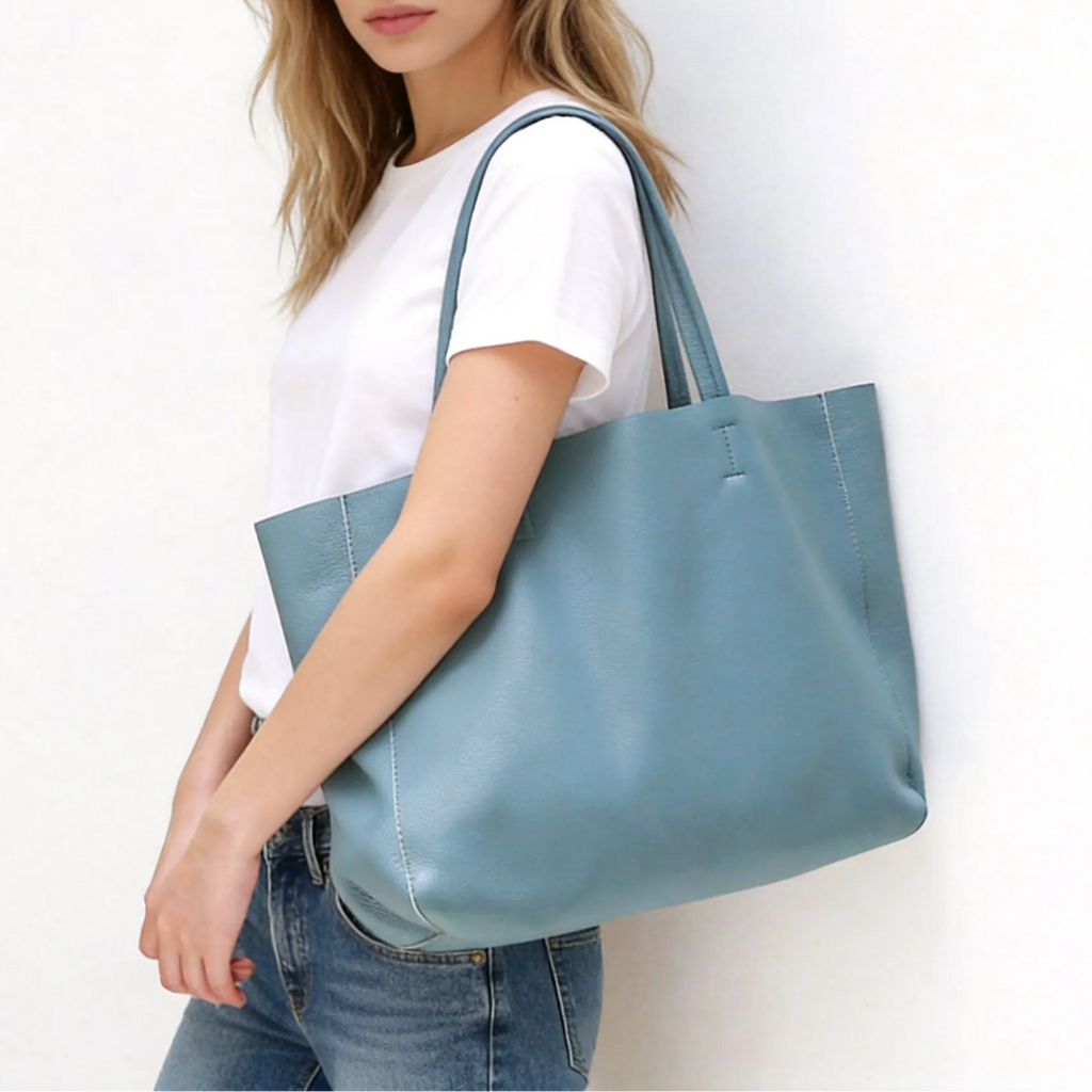 Woman holding a light blue tote bag against a white background