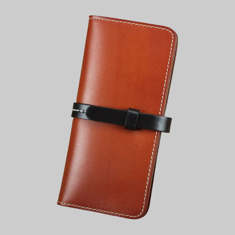 Brown leather wallet with a black strap on a brown background