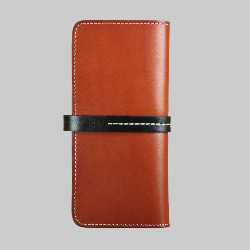 Brown leather wallet with a black strap on a textured brown background