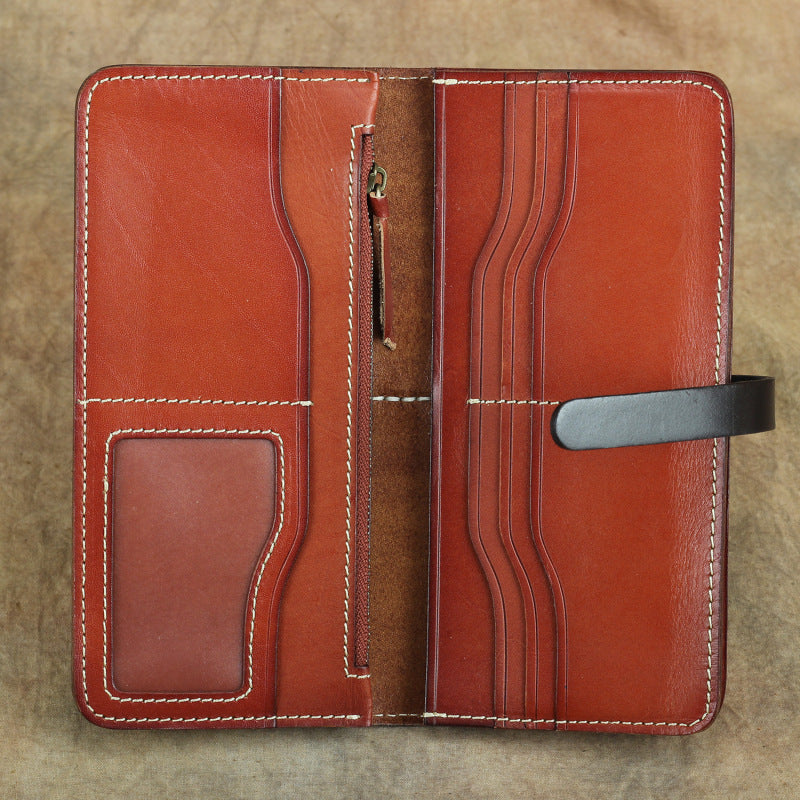 Brown leather wallet with stitching details on a textured surface