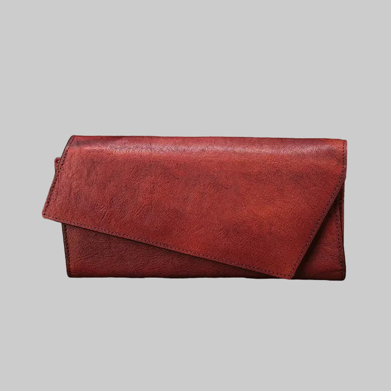 Red leather wallet on a rustic wooden surface with natural elements.