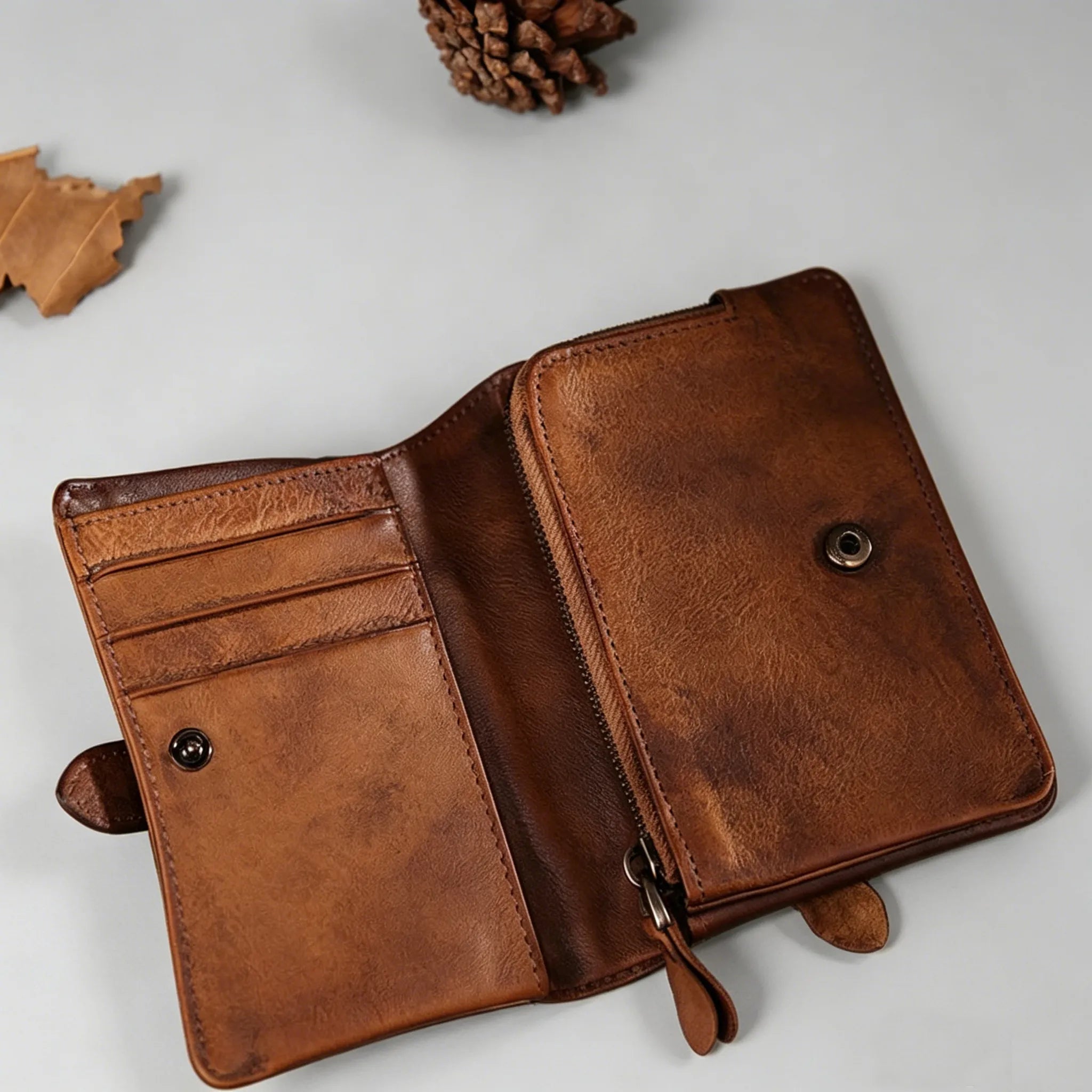 Brown leather wallet on a light gray surface with decorative elements.