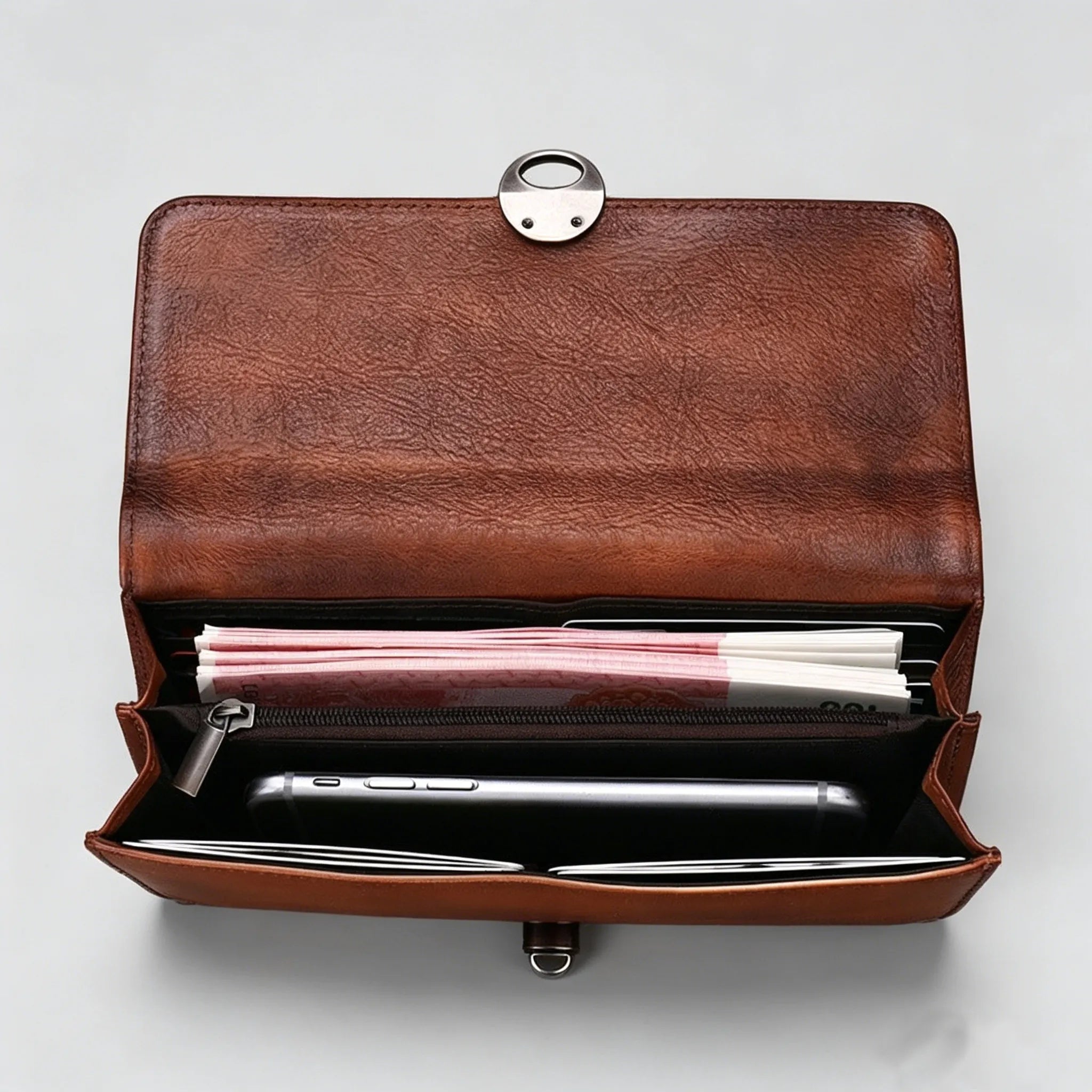 Brown leather clutch bag with compartments on a white background
