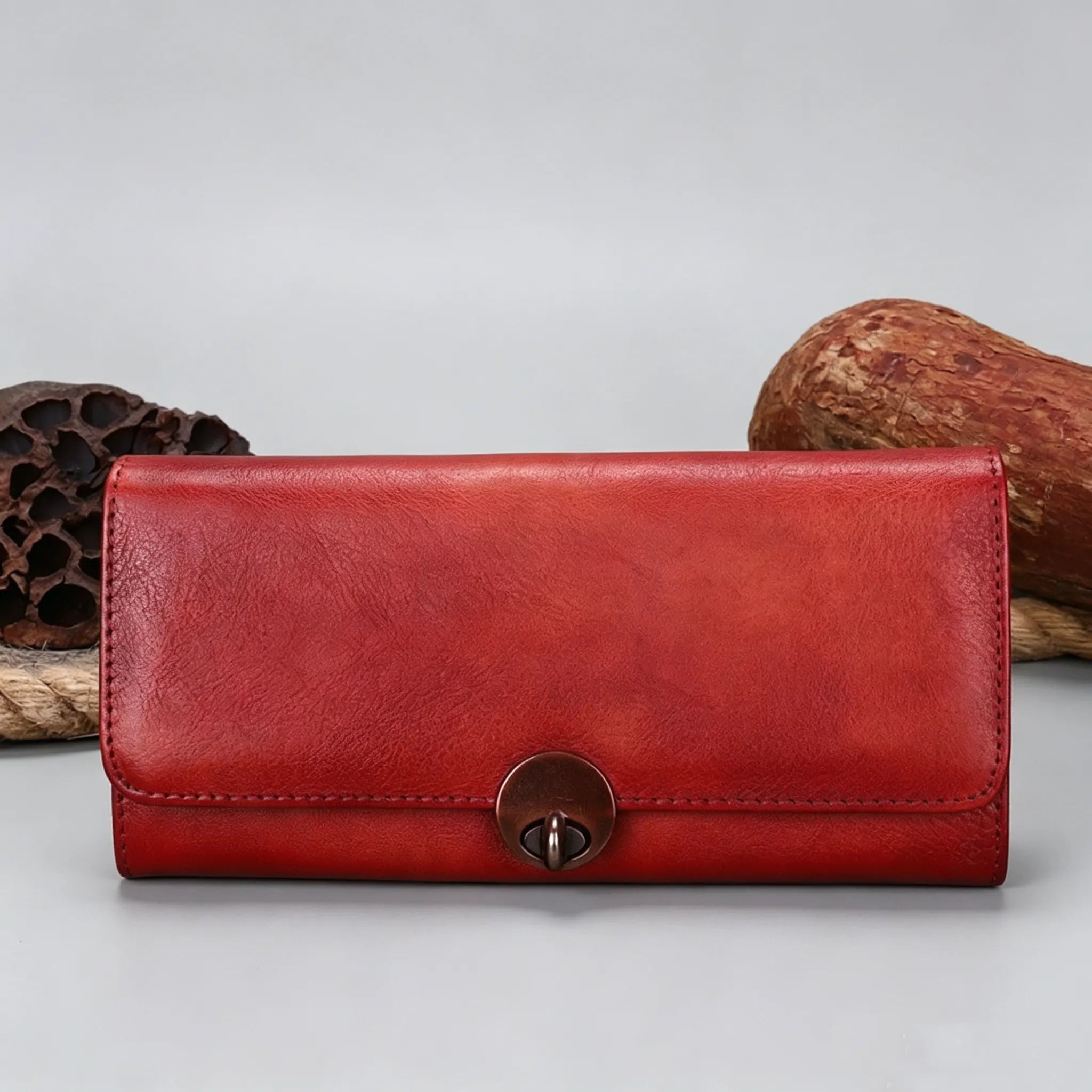 Red leather wallet with a metal clasp on a light gray background