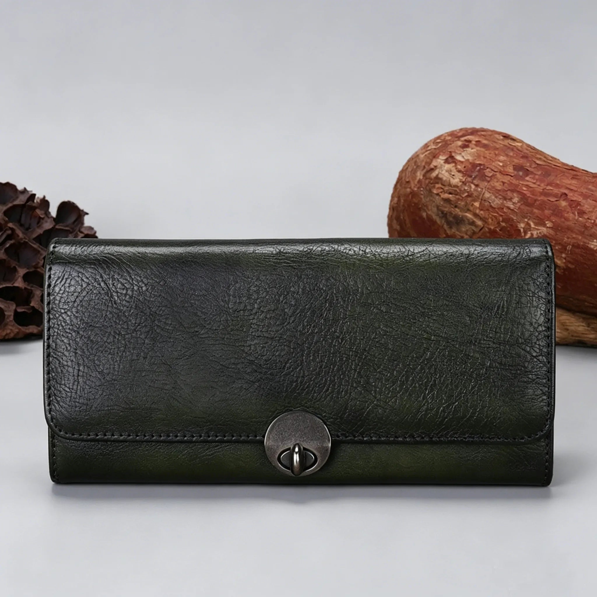 Black leather wallet with a metal clasp on a light gray background