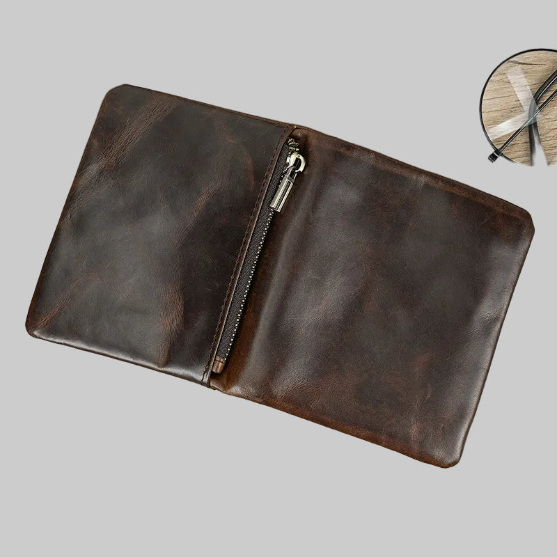 Brown leather clutch with zipper on a gray background