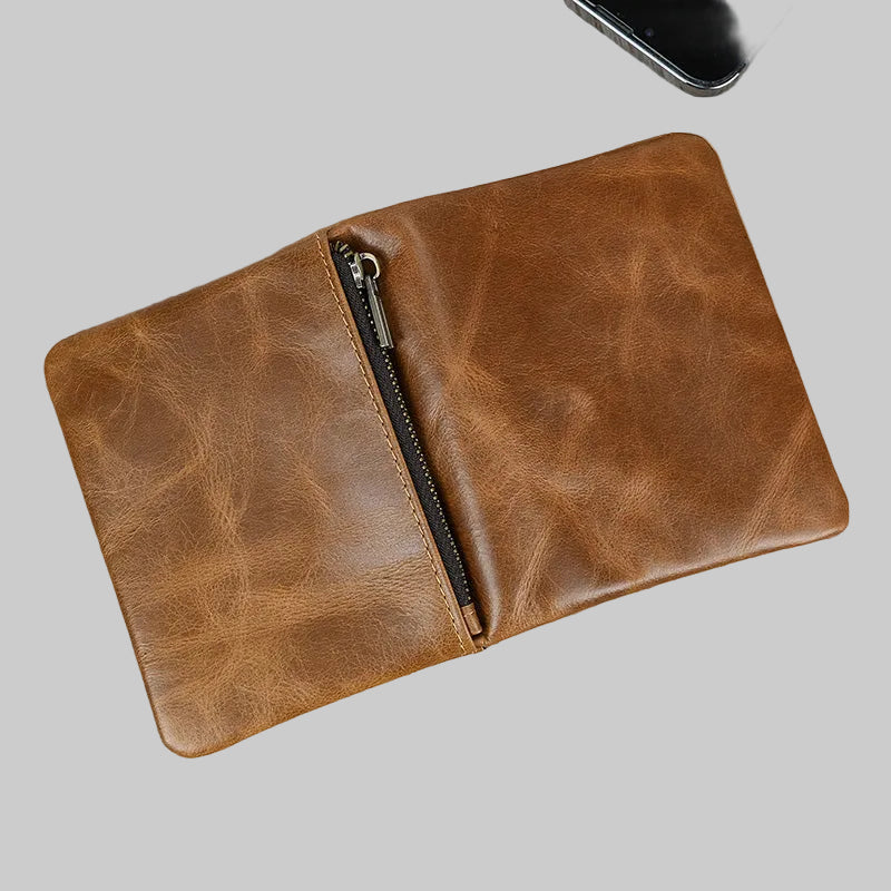 Brown leather wallet with a zipper on a wooden surface
