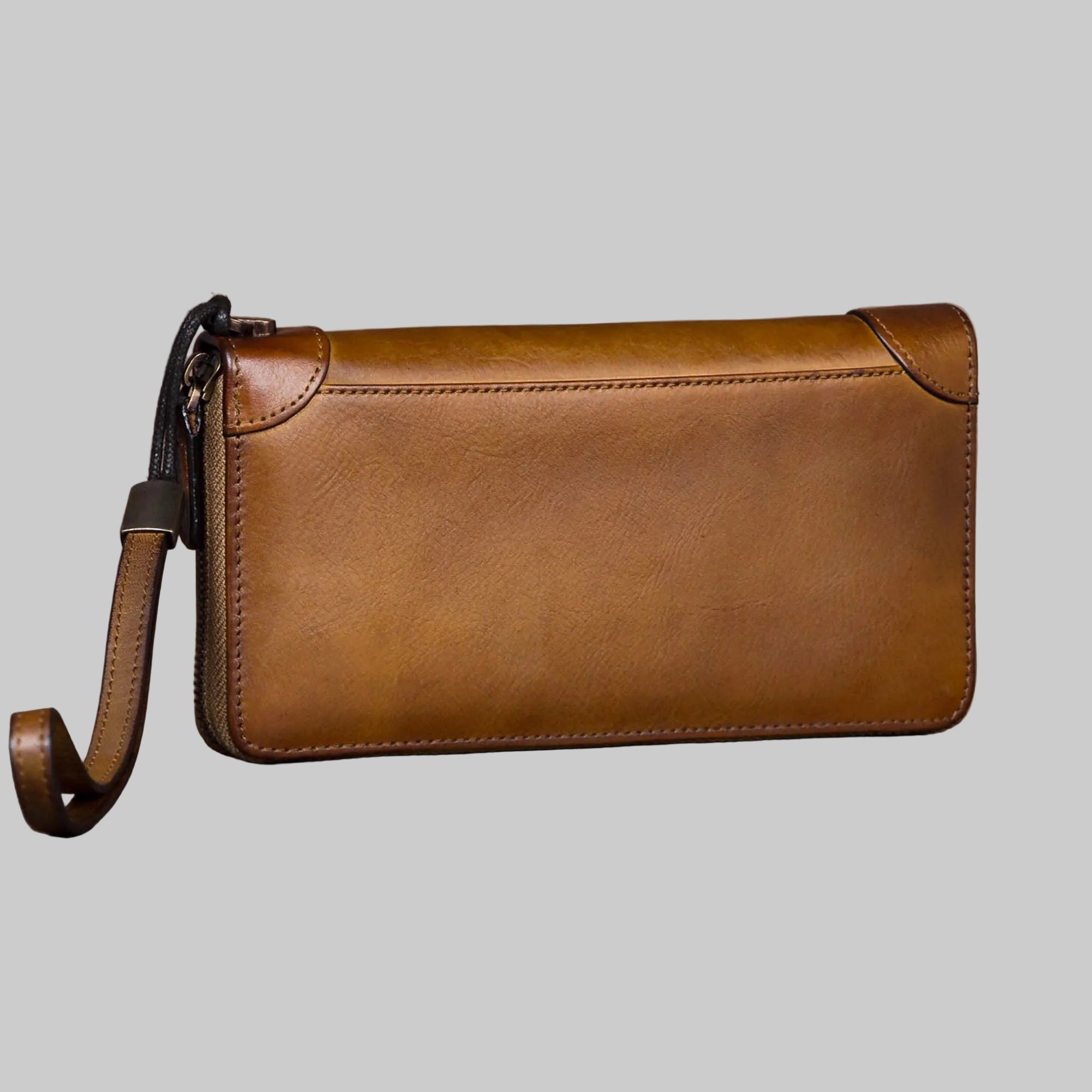 Brown leather clutch bag on a gray background