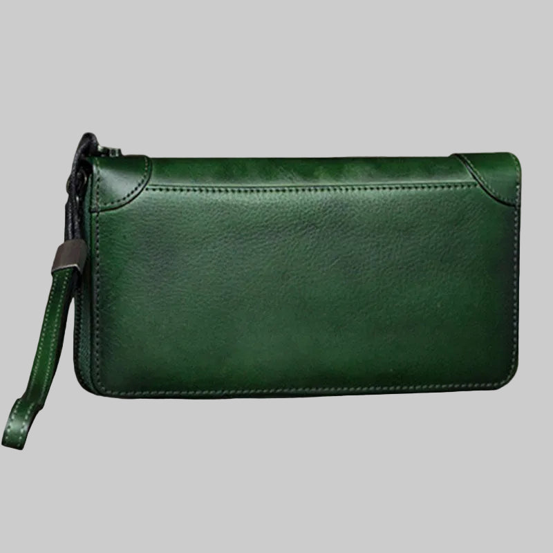 Green leather wallet with a strap on a wooden surface