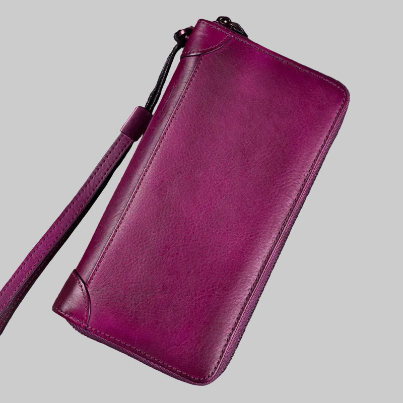 Purple leather wallet on a wooden surface with an old book in the background