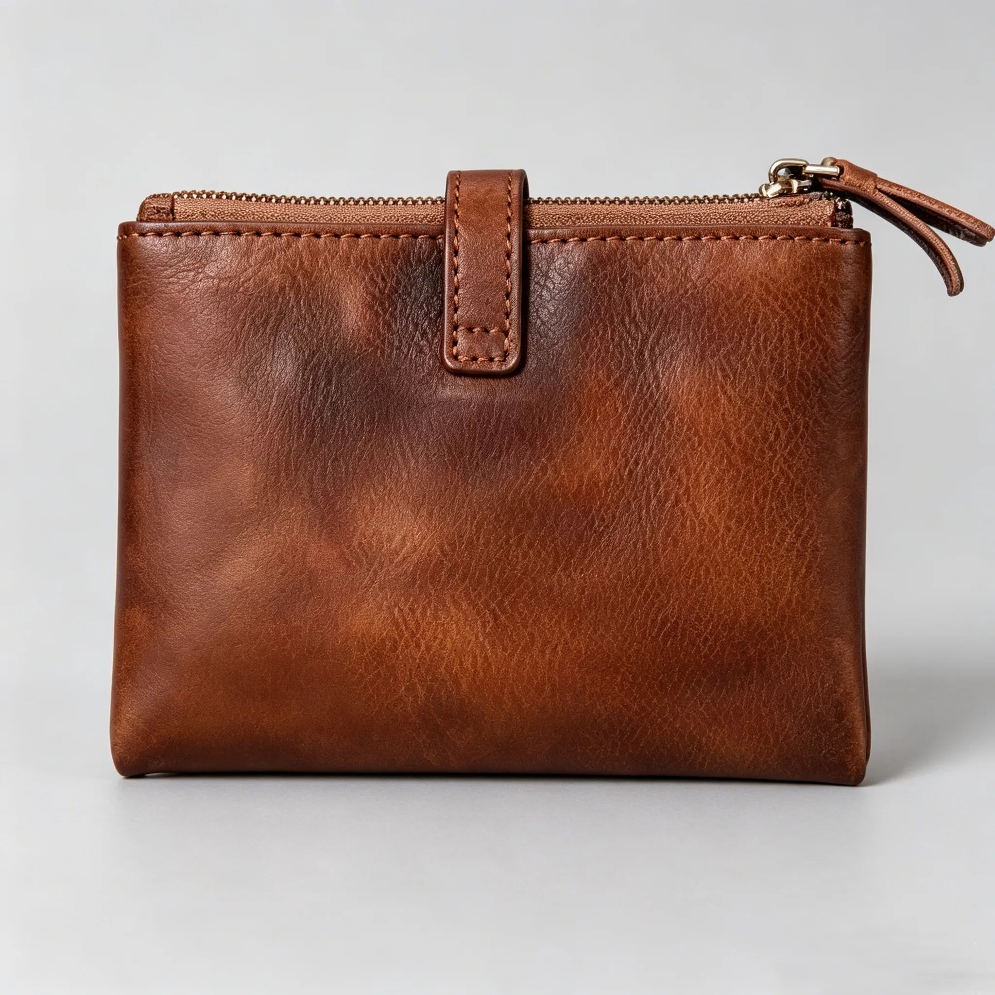 Brown leather clutch bag on a light gray background
