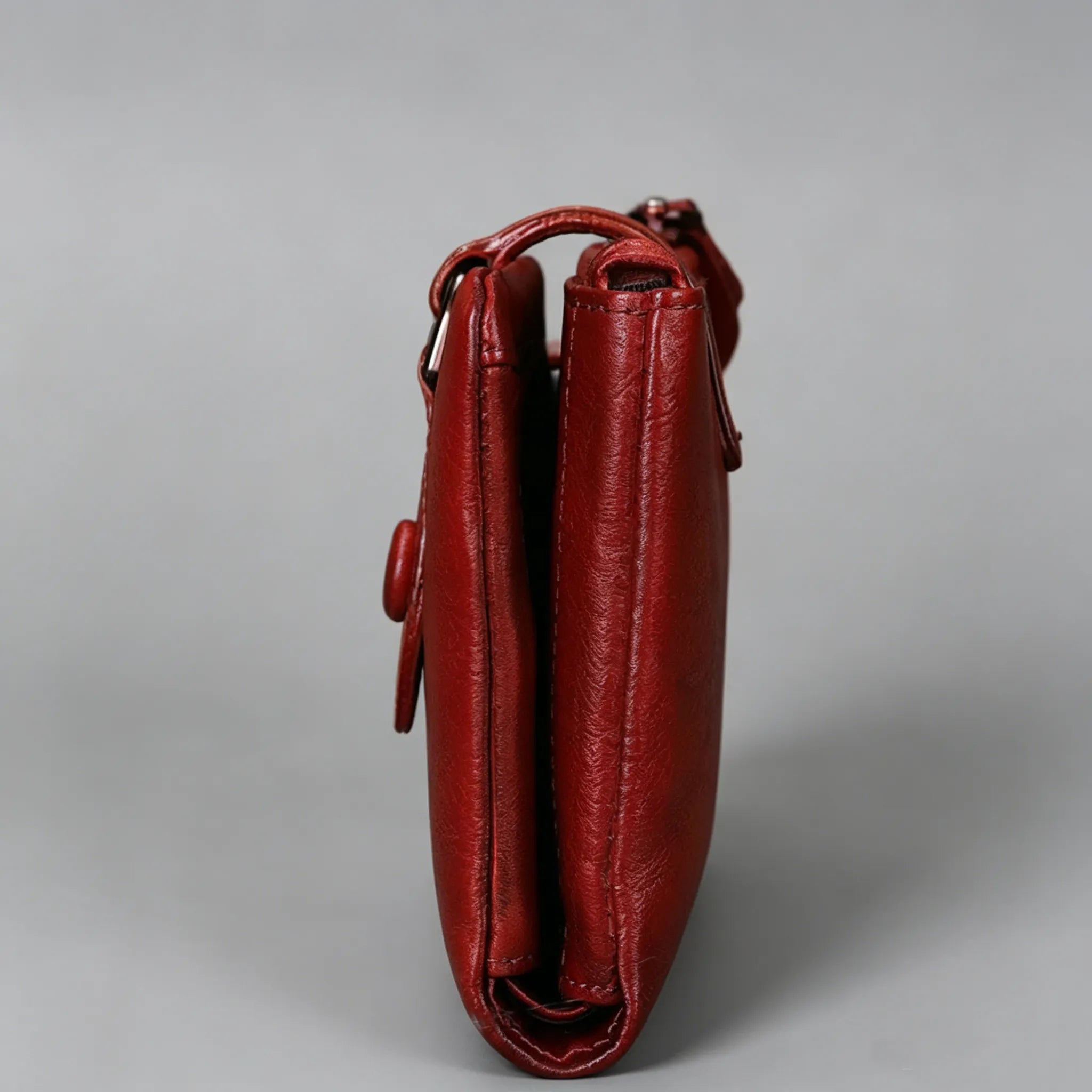 Red leather handbag on a gray background