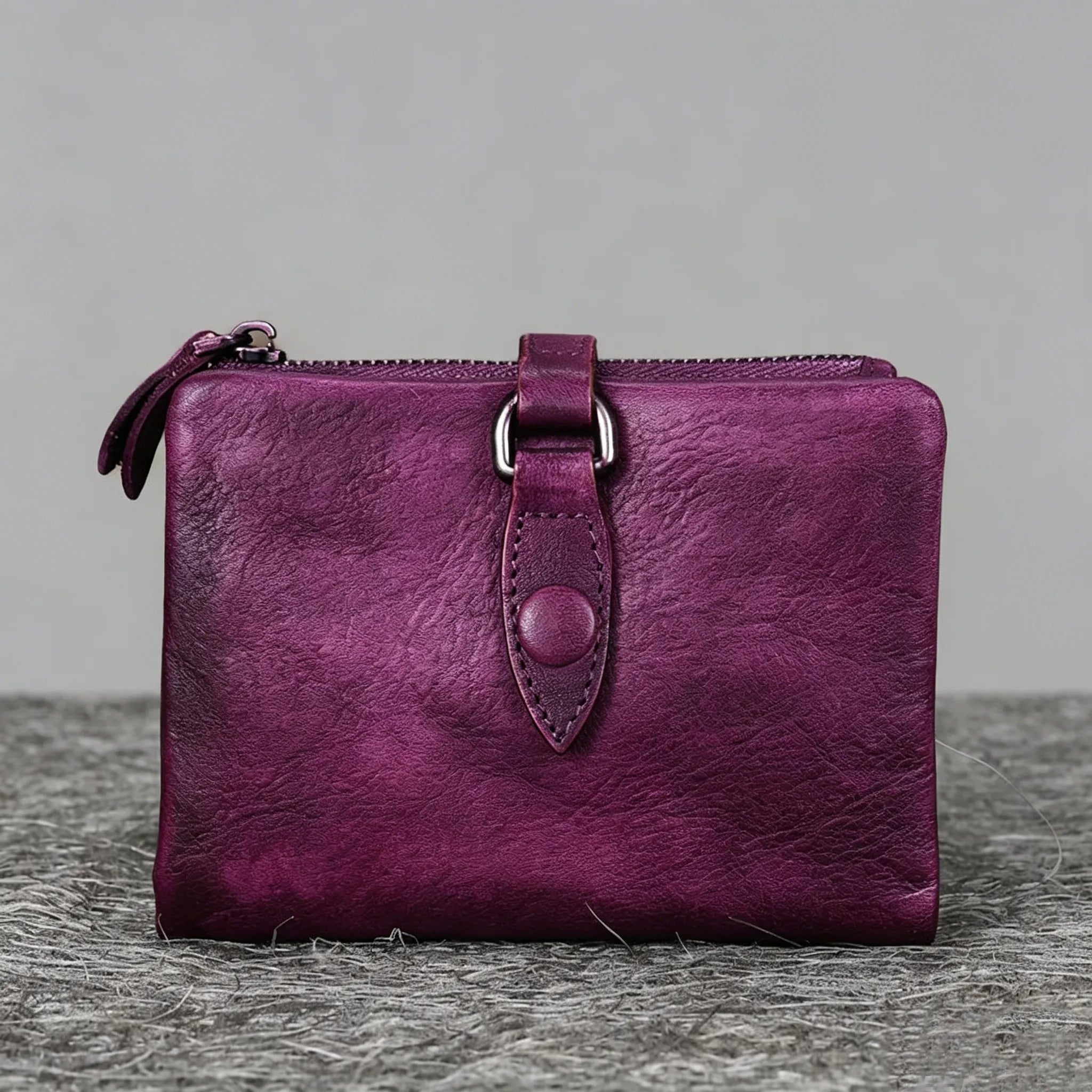 Purple leather wallet on a textured gray surface with a neutral background