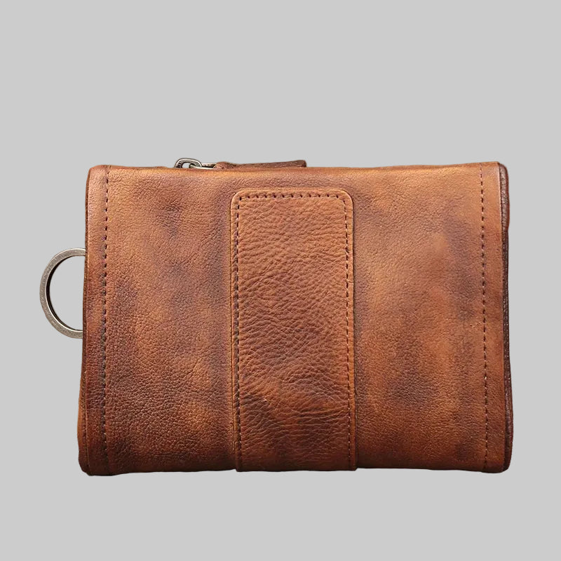 Brown leather wallet on a textured surface with a blurred background