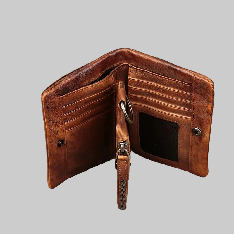 Brown leather wallet with keychain on a textured surface