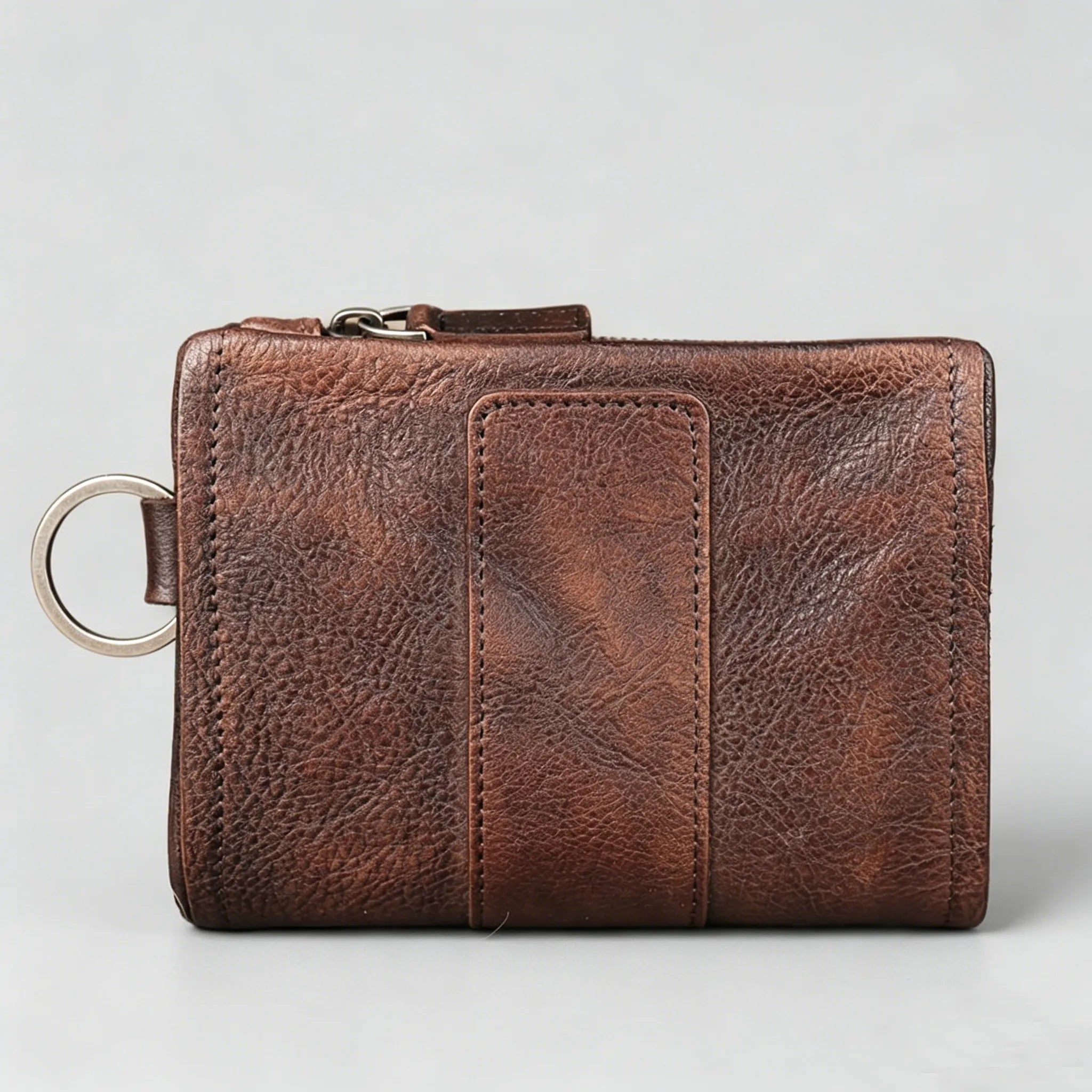 Brown leather wallet with key ring on a light gray background
