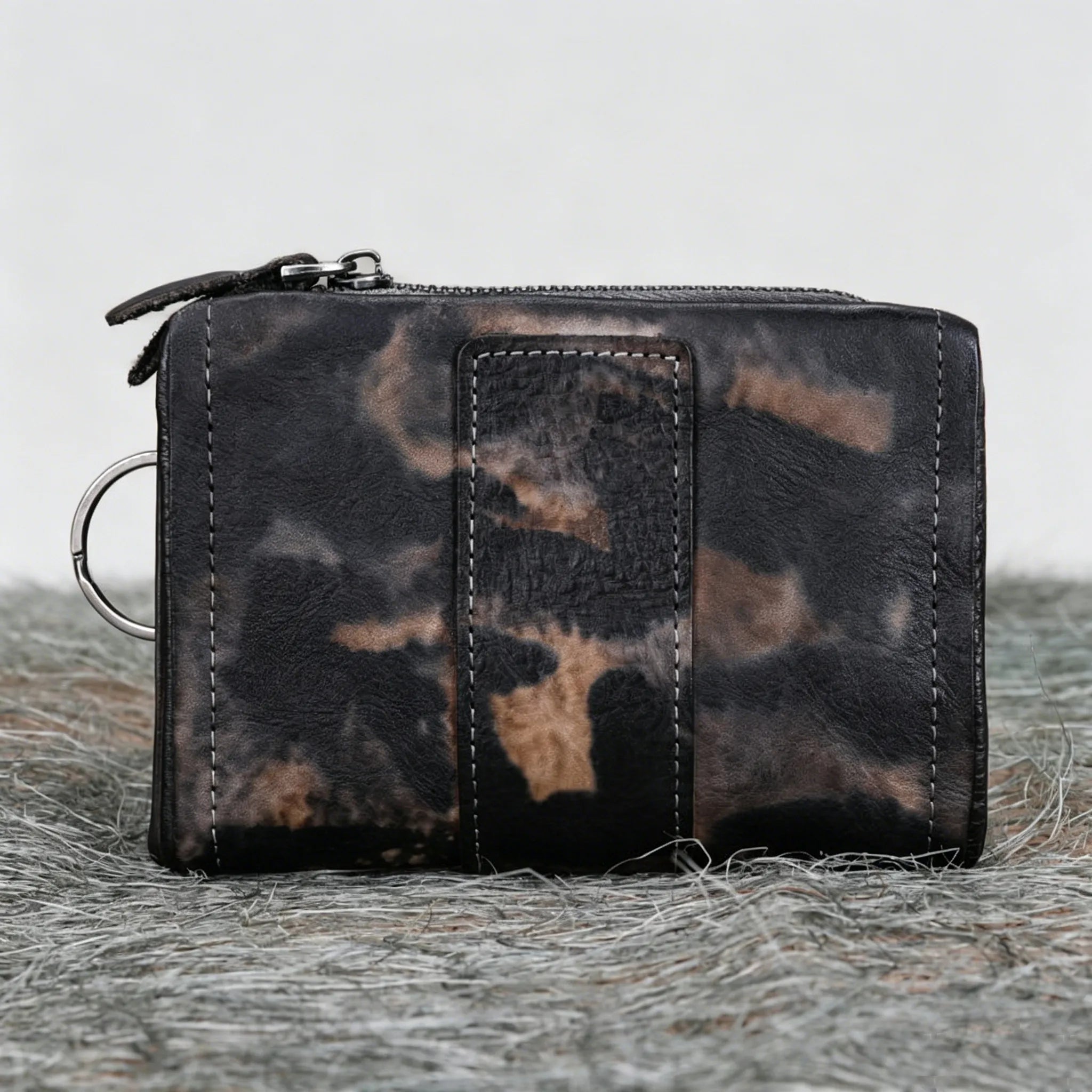 Leopard print wallet on a textured surface with a neutral background