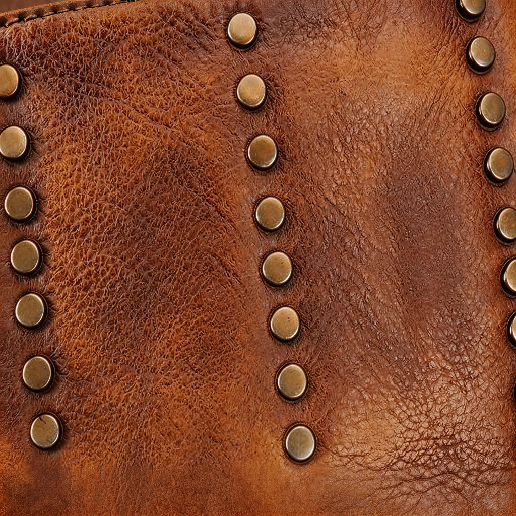 Close-up of a brown leather bag with gold studs