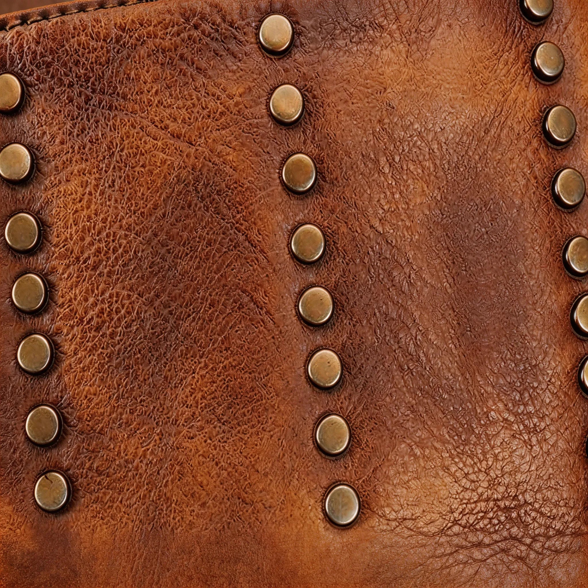Close-up of a brown leather bag with gold studs
