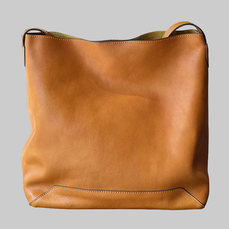 Brown leather bucket tote bag on a white background