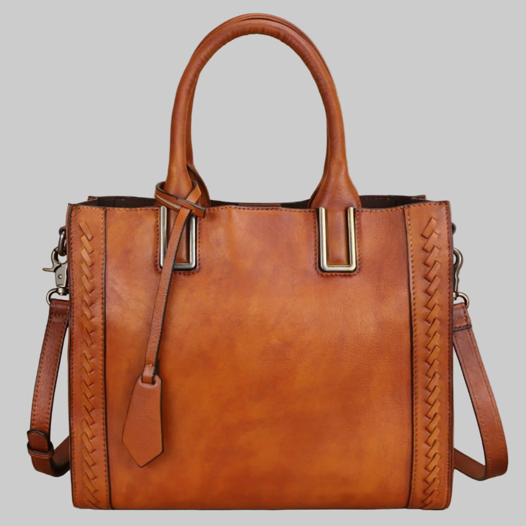A brown genuine leather satchel handbag with polyester accents, featuring a vintage design with two handles and a detachable shoulder strap.