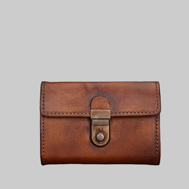 Brown leather wallet with a metal buckle on a textured brown background