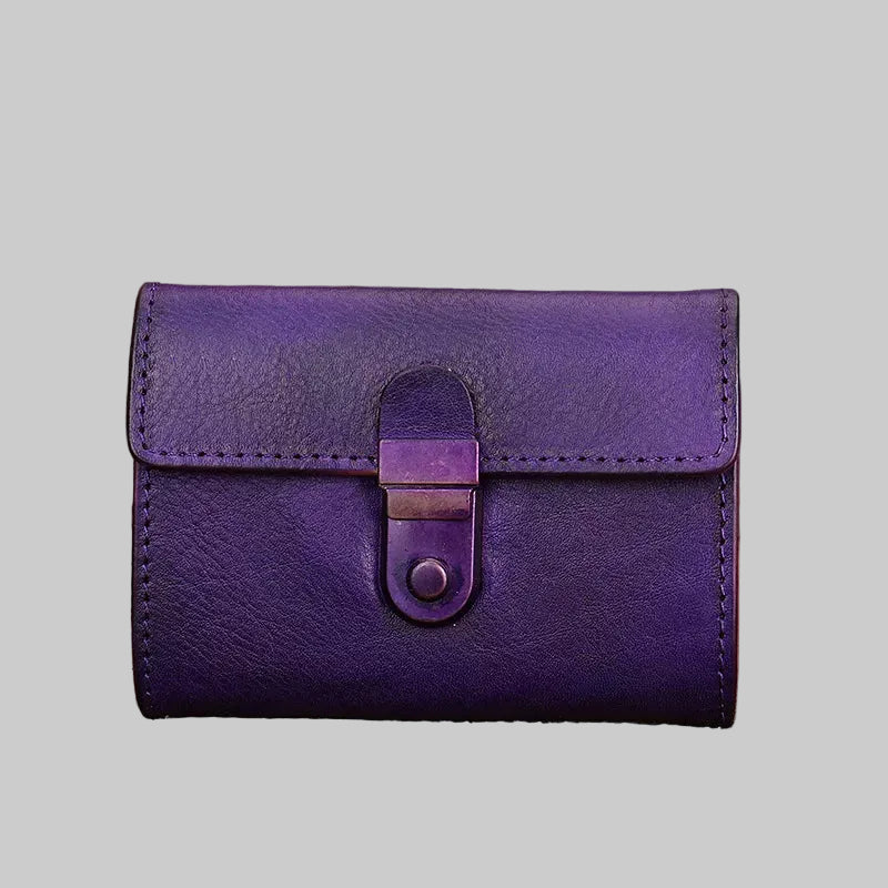 Purple leather wallet with a clasp on a wooden surface