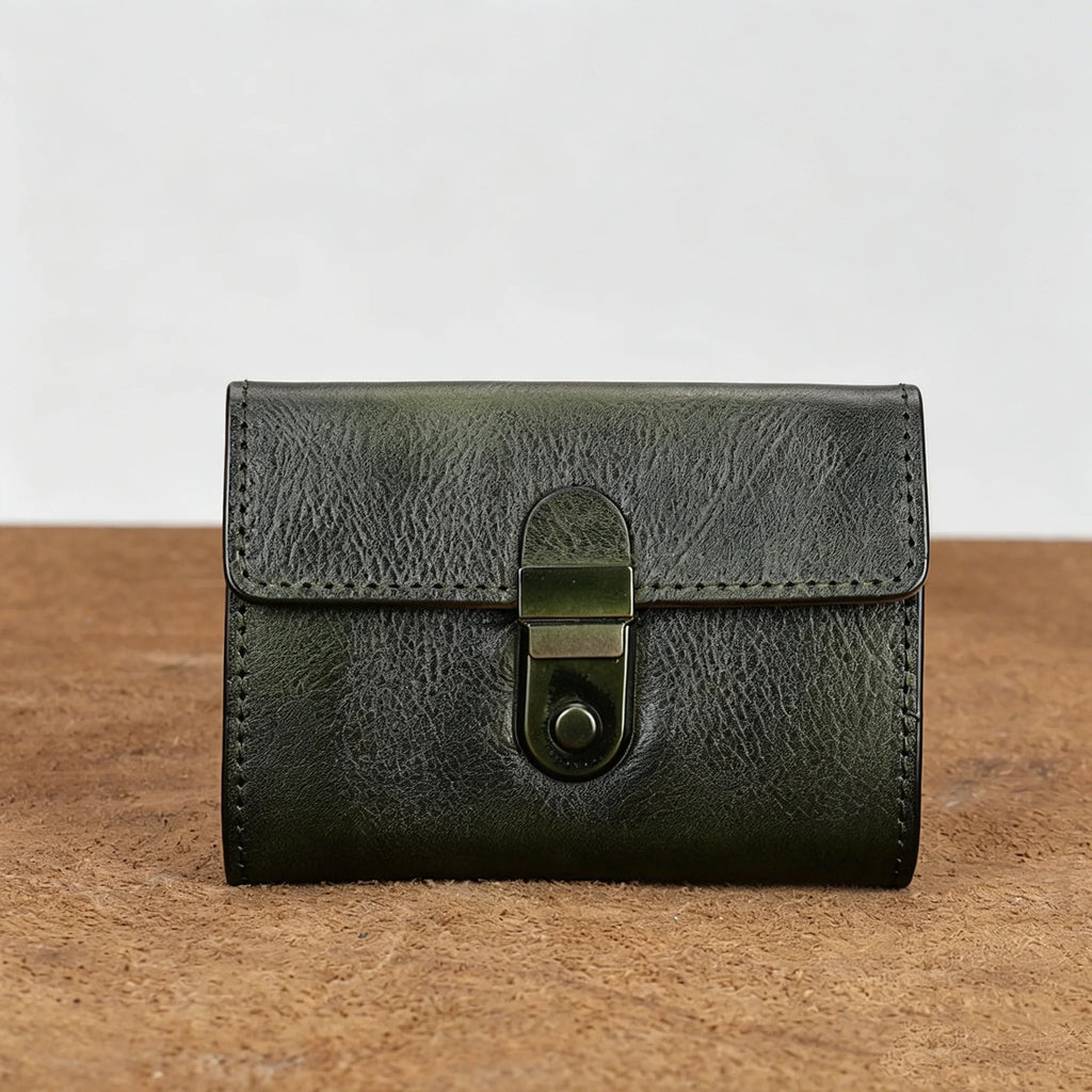 Green leather wallet with a buckle on a wooden surface