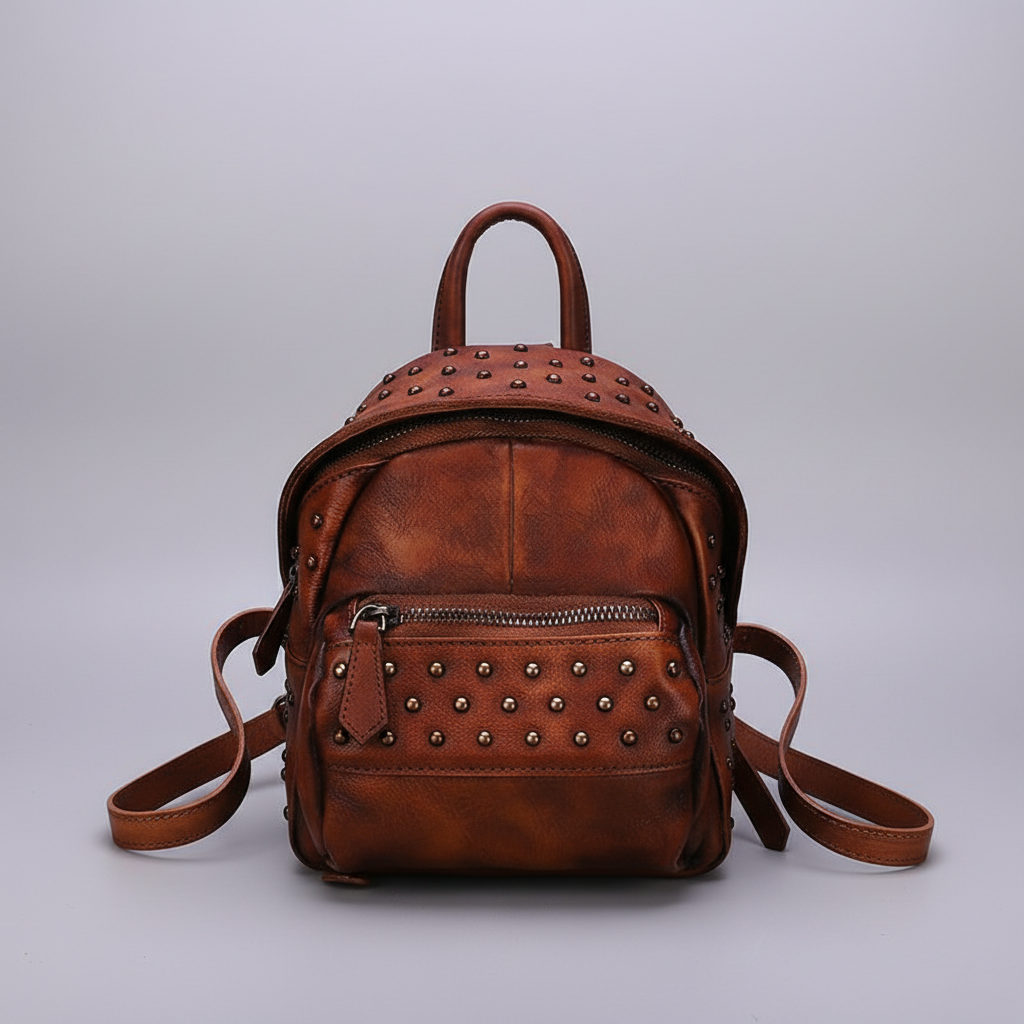 Brown leather backpack with studs on a light gray background