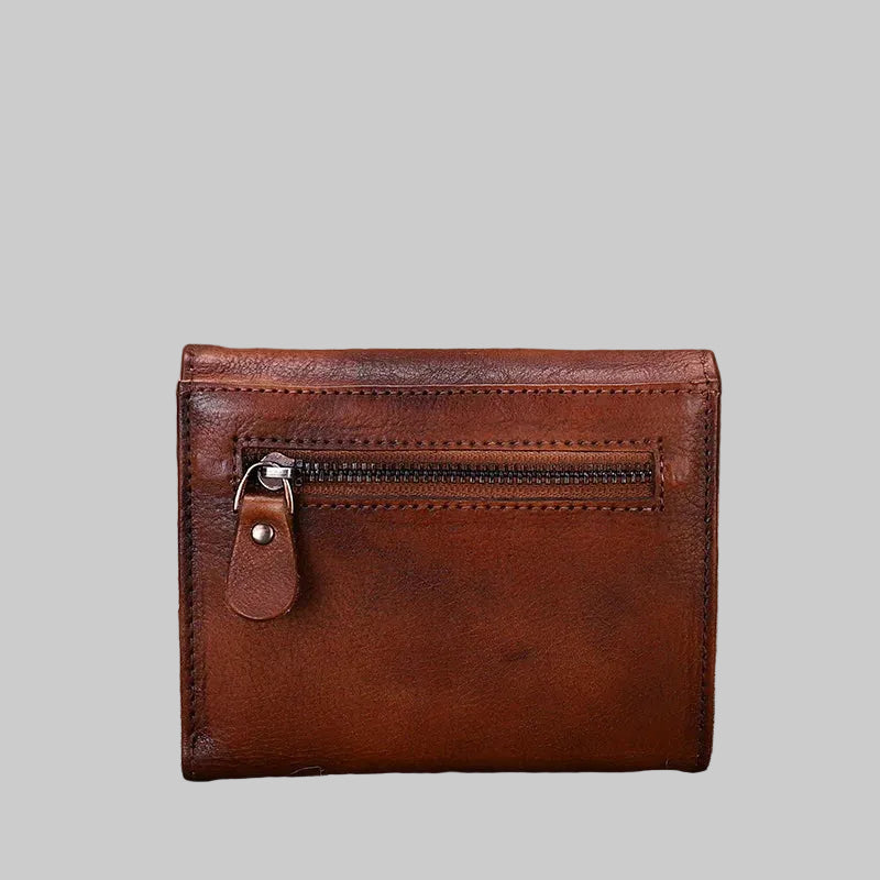Brown leather wallet with a zipper on a rustic wooden surface.