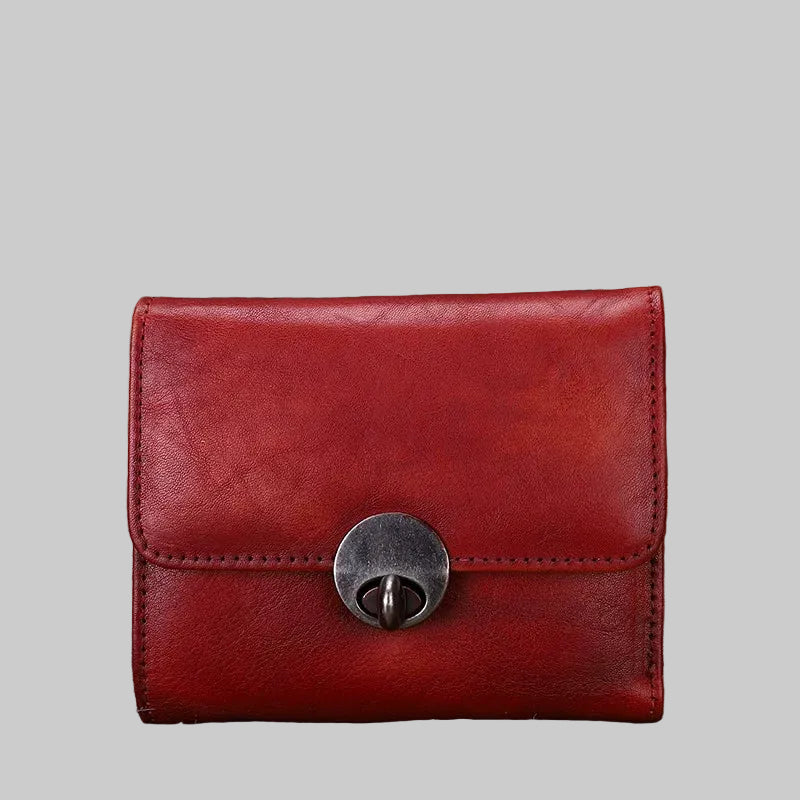 Red leather wallet with a metallic clasp on a textured surface