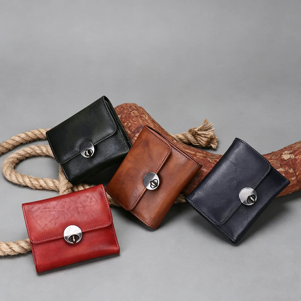 Four leather wallets in black, brown, red, and navy on a gray background.
