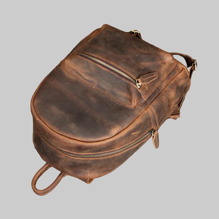 Brown leather backpack on a gray background