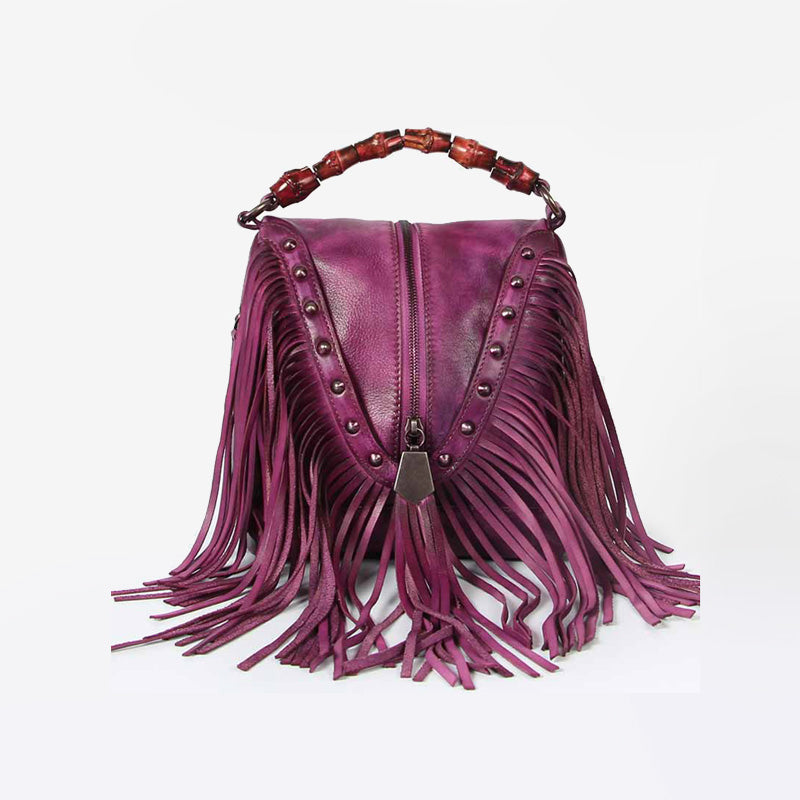 A purple leather fringe crossbody handbag with a shoulder strap and metal accents.