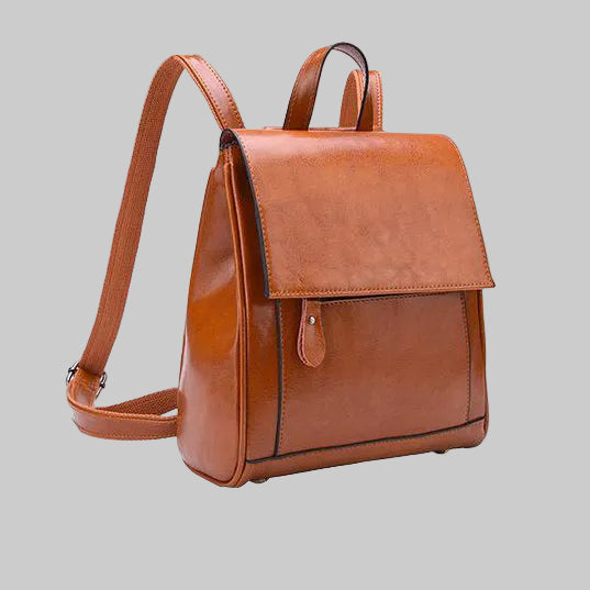 Brown leather backpack on a gray background