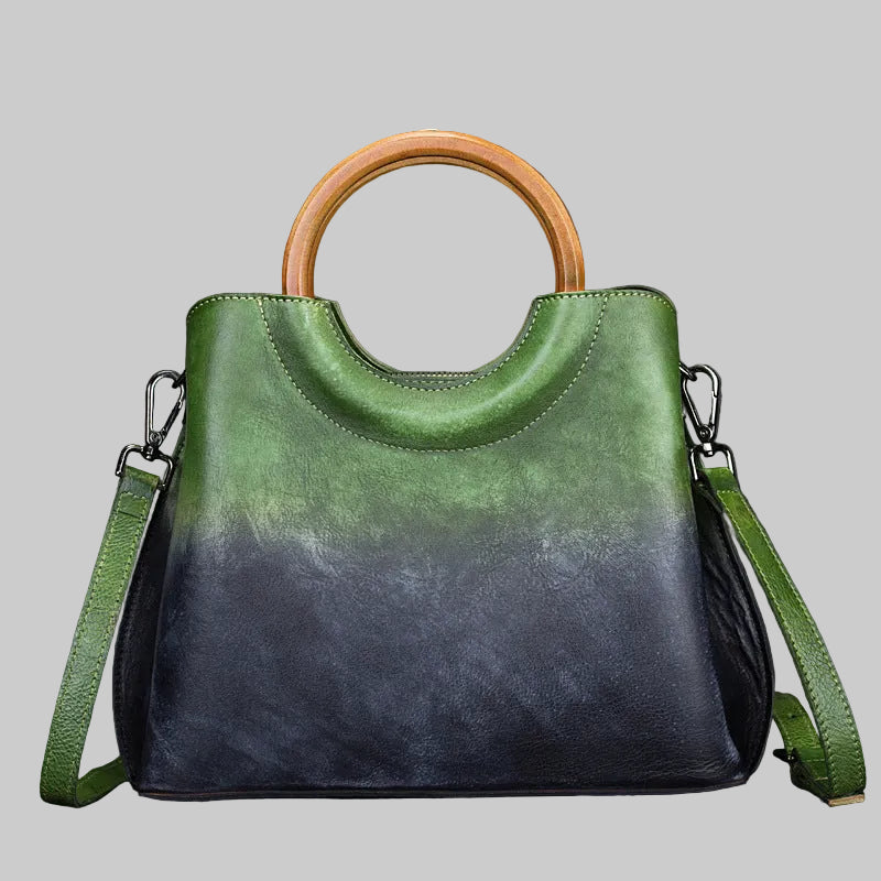 Green and black handbag with wooden handle on a dark background