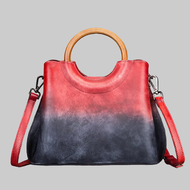 Red and black handbag with wooden handle on a dark background