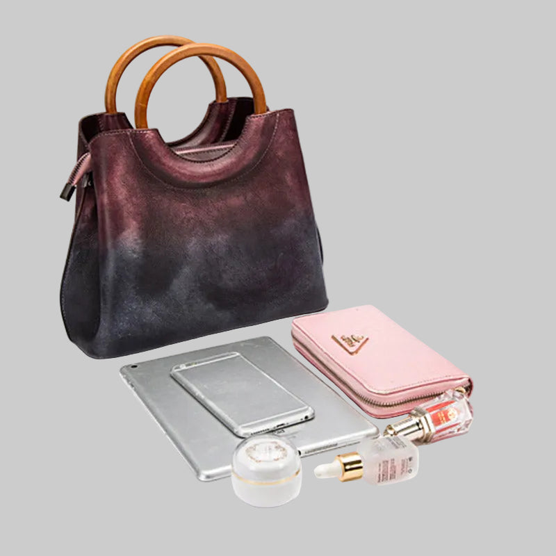 Purple handbag with a pink wallet, mirror, and skincare products on a white background