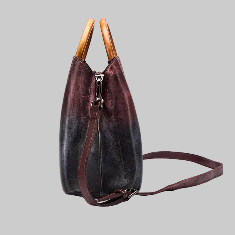 Brown leather handbag with wooden handles on a white background