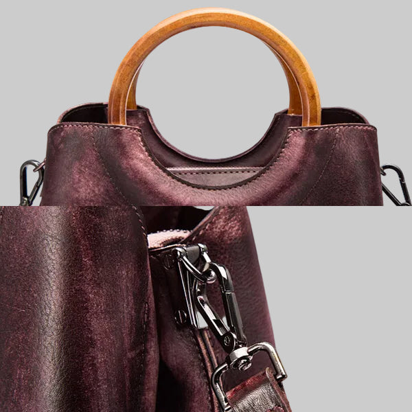 Close-up of a purple handbag with a wooden handle on a gray background