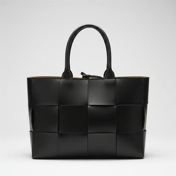 Black woven handbag on a light gray background