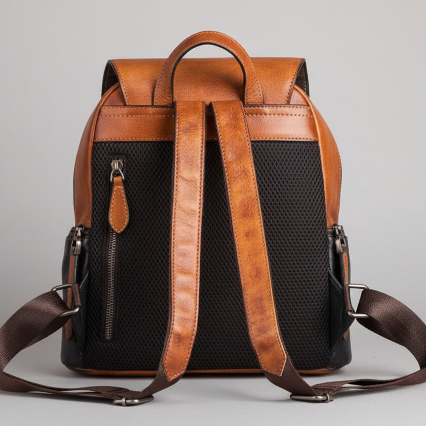 Brown leather backpack with black mesh back on a gray background