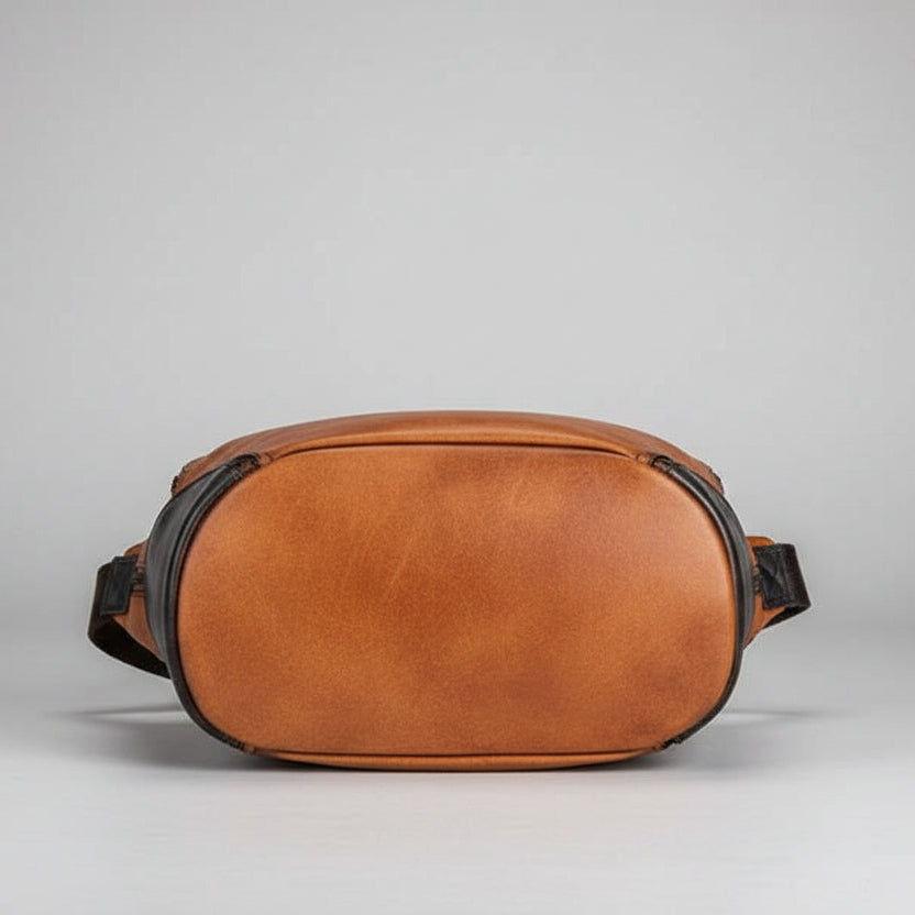 Brown leather waist bag on a gray background