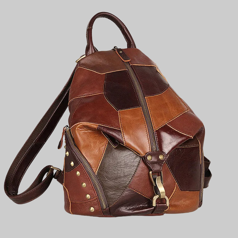 Brown leather patchwork backpack with gold accents on a textured surface